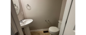 a bathroom with a toilet, sink and mirror