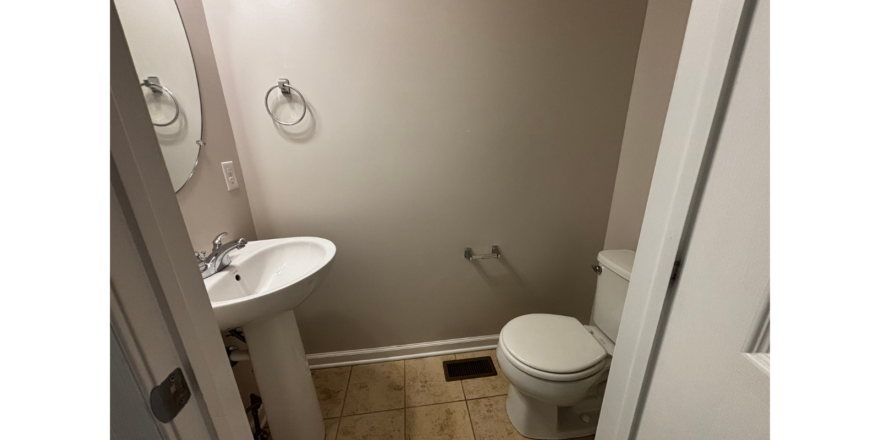 a bathroom with a toilet, sink and mirror