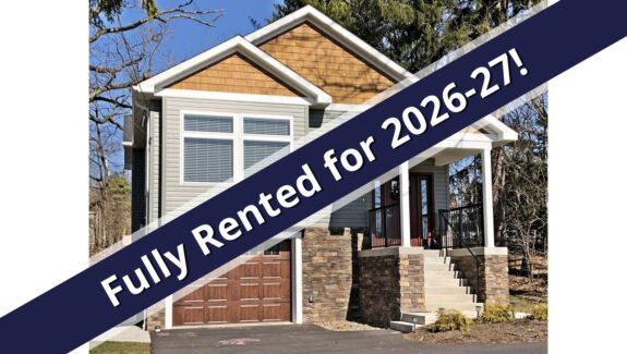 a house for sale with a blue ribbon in front of it