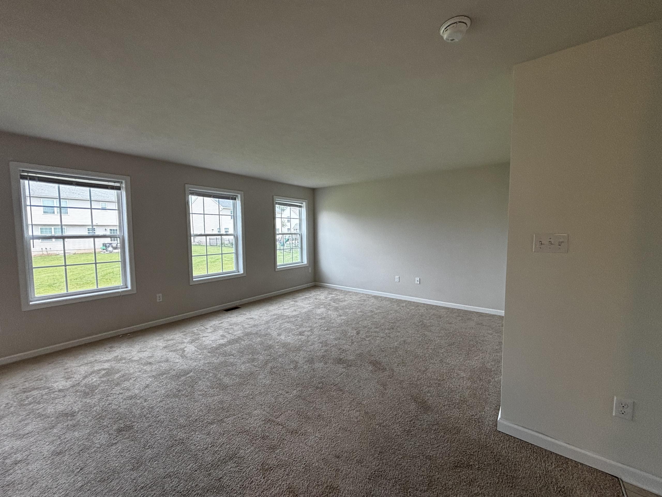 Empty living room with carpet and windows