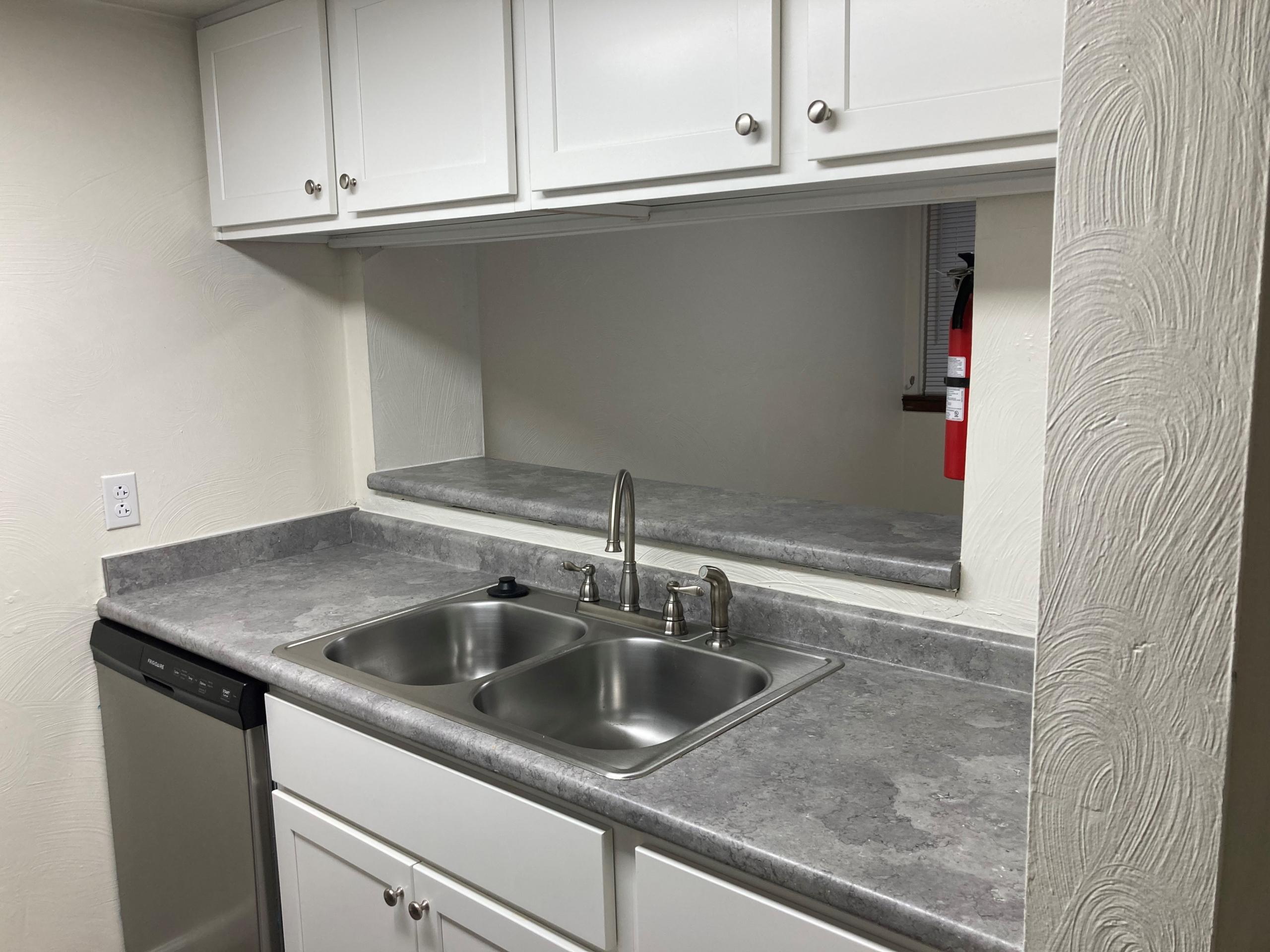 Gray kitchen countertop with sink and cabinets
