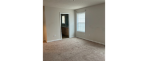 an empty room with a door and a window
