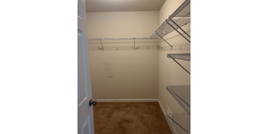a walk in closet with a closet door open