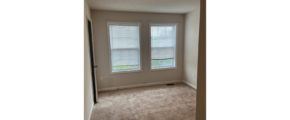 an empty room with two windows in it