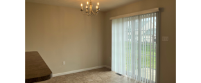 a living room with a chandelier and sliding glass doors