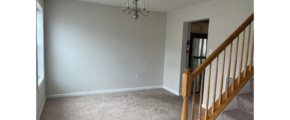 an empty room with stairs and a chandelier