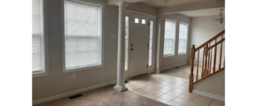an empty room with three windows and a door