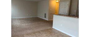 an empty living room with a bar in the corner