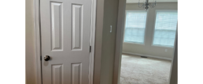 a white door in a room with a chandelier
