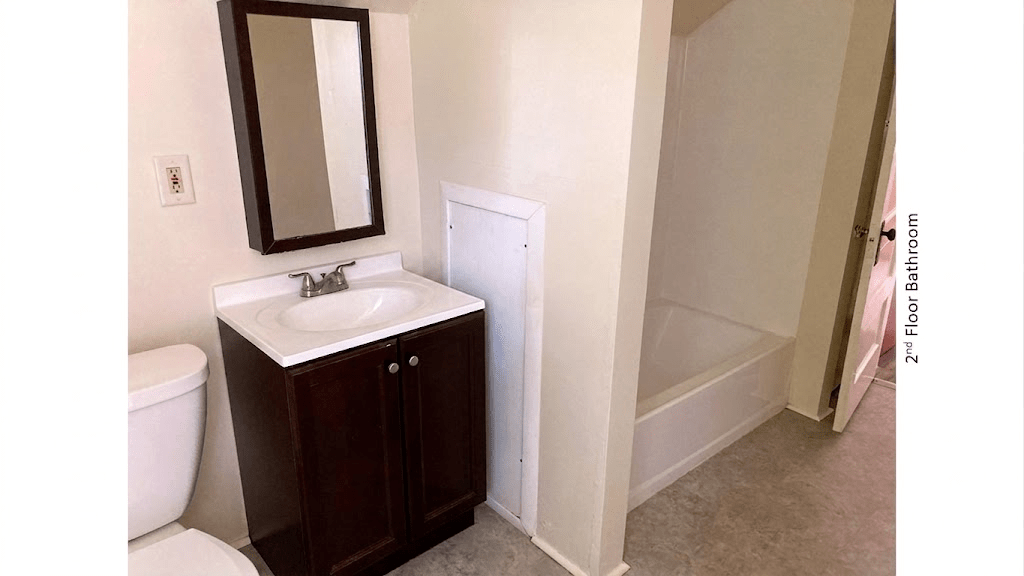 Bathroom with vanity, toilet, and tub