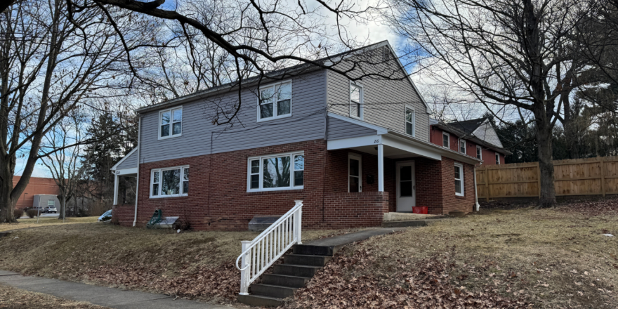a red brick house with a white picket fence