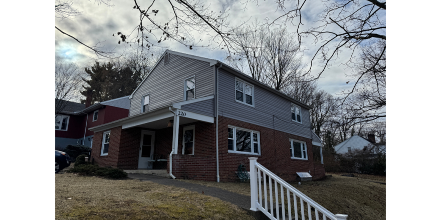 a red brick house with a white picket fence