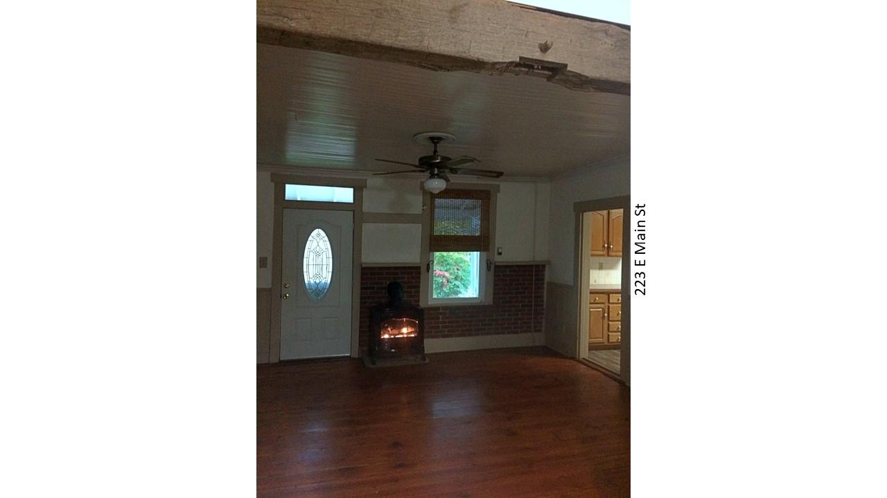 Living room with wood stove and kitchen view