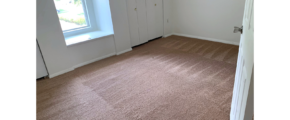Unfurnished, carpeted bedroom with built in storage bench