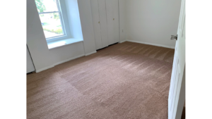 Unfurnished, carpeted bedroom with built in storage bench