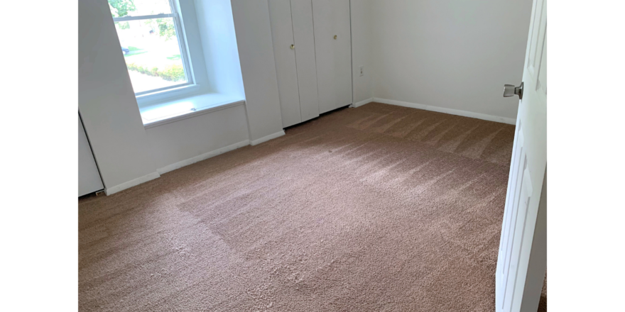 Unfurnished, carpeted bedroom with built in storage bench