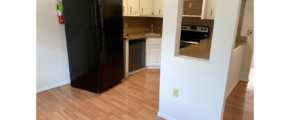 U-Shaped kitchen with white cabinets and stainless steel appliances and black fridge