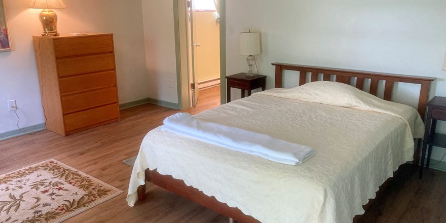 Bedroom with full bed, two end tables with lamps and a dresser with a lamp