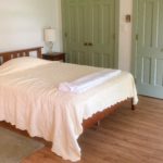 Bedroom with full bed, two end tables with lamps and two closets