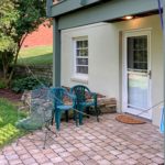 Brick patio with three chairs and plants