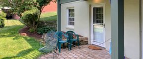 Brick patio with three chairs and plants