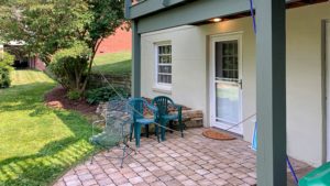 Brick patio with three chairs and plants