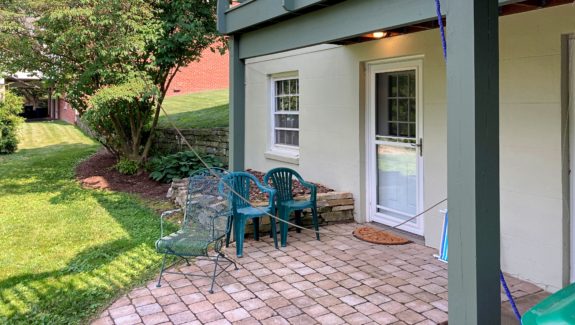 Brick patio with three chairs and plants