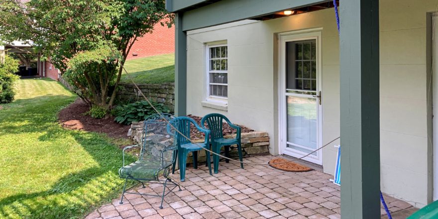 Brick patio with three chairs and plants