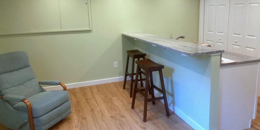 Kitchen counter with barstool seating and a recliner