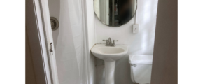Small bathroom with shower stall, pedestal, and toilet