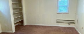 Unfurnished, carpeted bedroom with built in shelving
