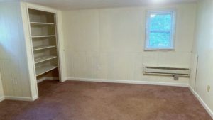 Unfurnished, carpeted bedroom with built in shelving