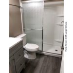 Bathroom with stall shower, toilet, and vanity