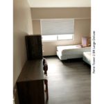 Bedroom with two beds, a dresser, and a desk