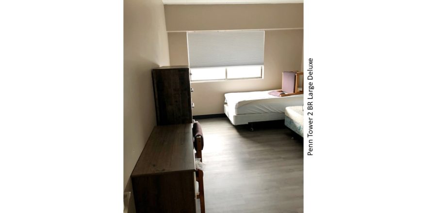 Bedroom with two beds, a dresser, and a desk