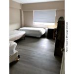 Bedroom with three beds, a dresser, and a desk