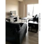 Living room with sofa, loveseat, tv, tv stand, coffee table, side table and door to balcony