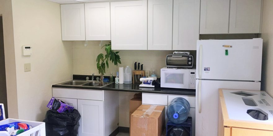 Kitchenette with appliances, cabinets, and sink