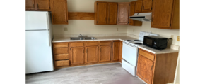 a kitchen with white appliances and wooden cabinets