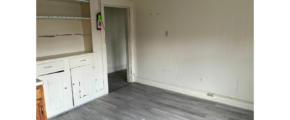 an empty room with white cabinets and a door
