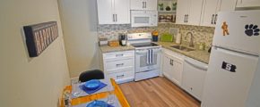 Kitchen with dining table, range oven, microwave, dishwasher, and refridgerator