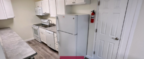 Galley kitchen with range oven, microwave, dishwasher, and refridgerator