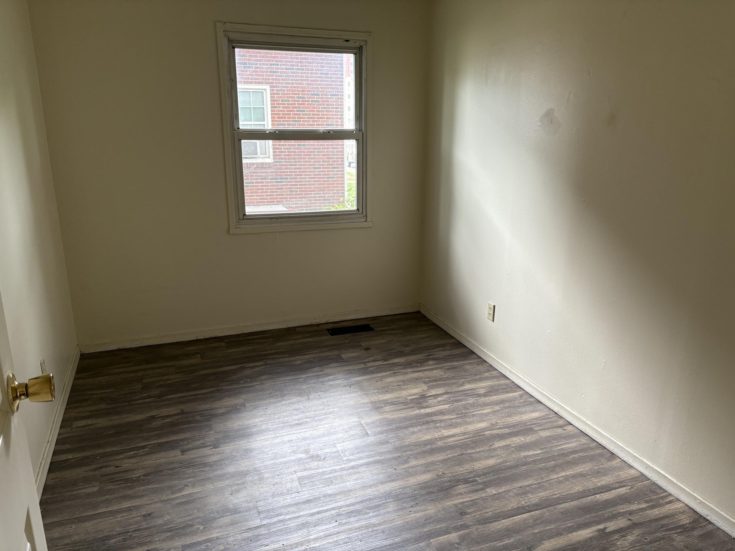 Empty room with wood-look floor and window
