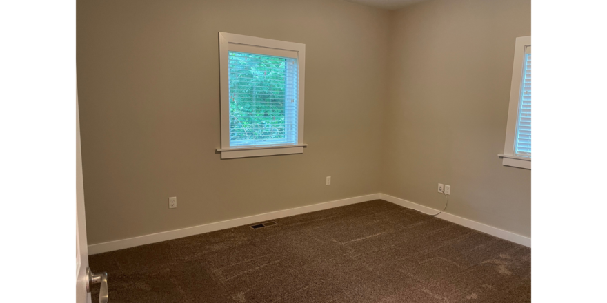 a empty room with a window and a ceiling fan