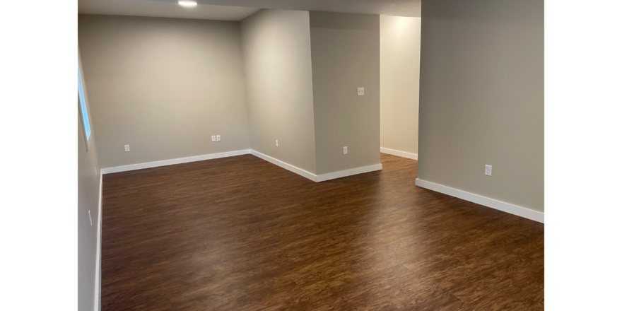 an empty living room with hard wood floors