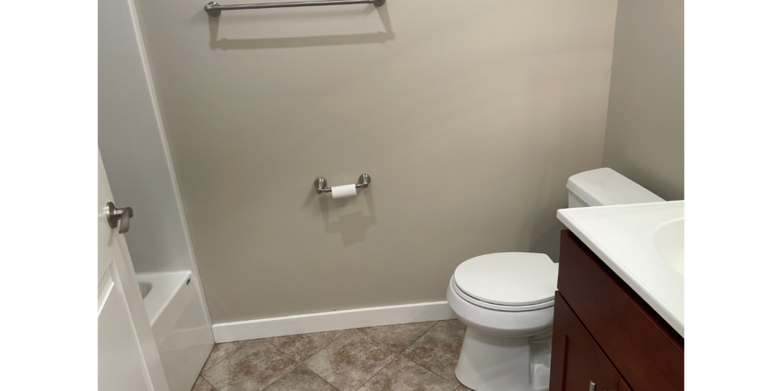 a bathroom with a toilet, sink, and shower