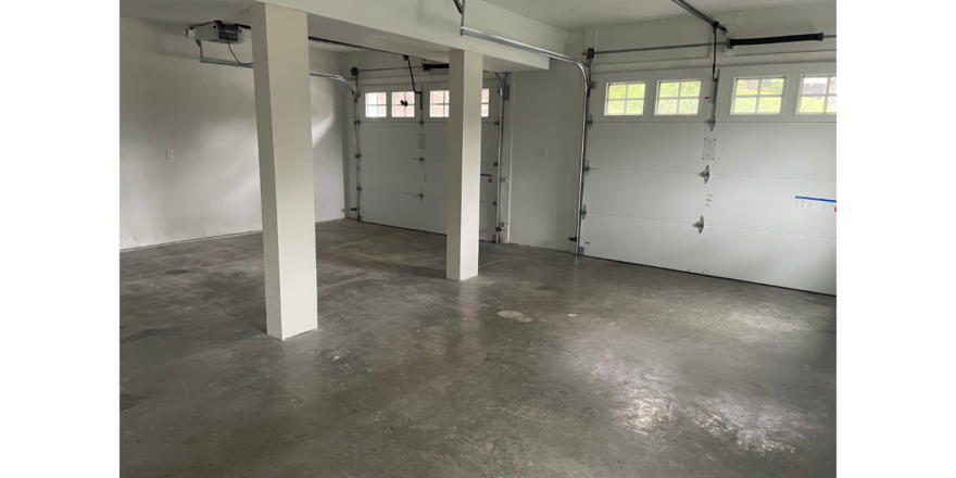 an empty garage with two garage doors open