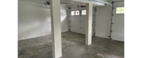 an empty garage with two garage doors open