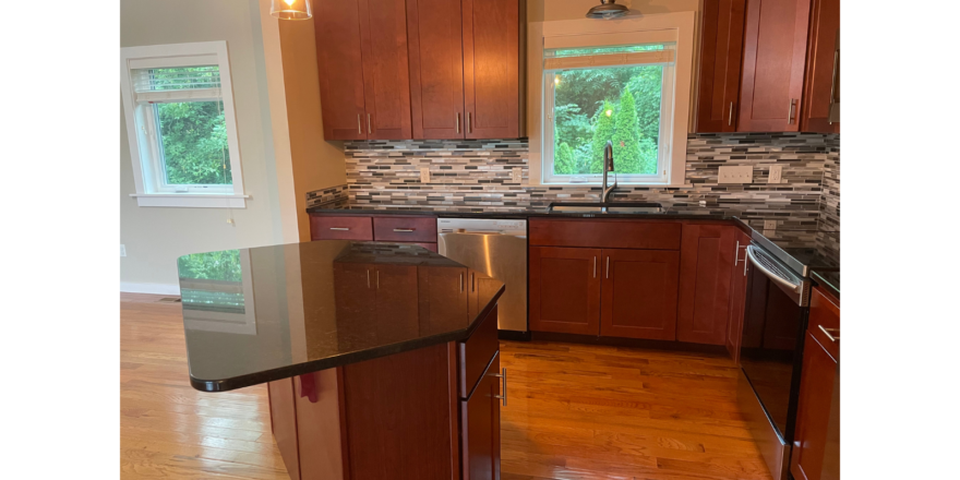 a kitchen with wooden cabinets and a black counter top