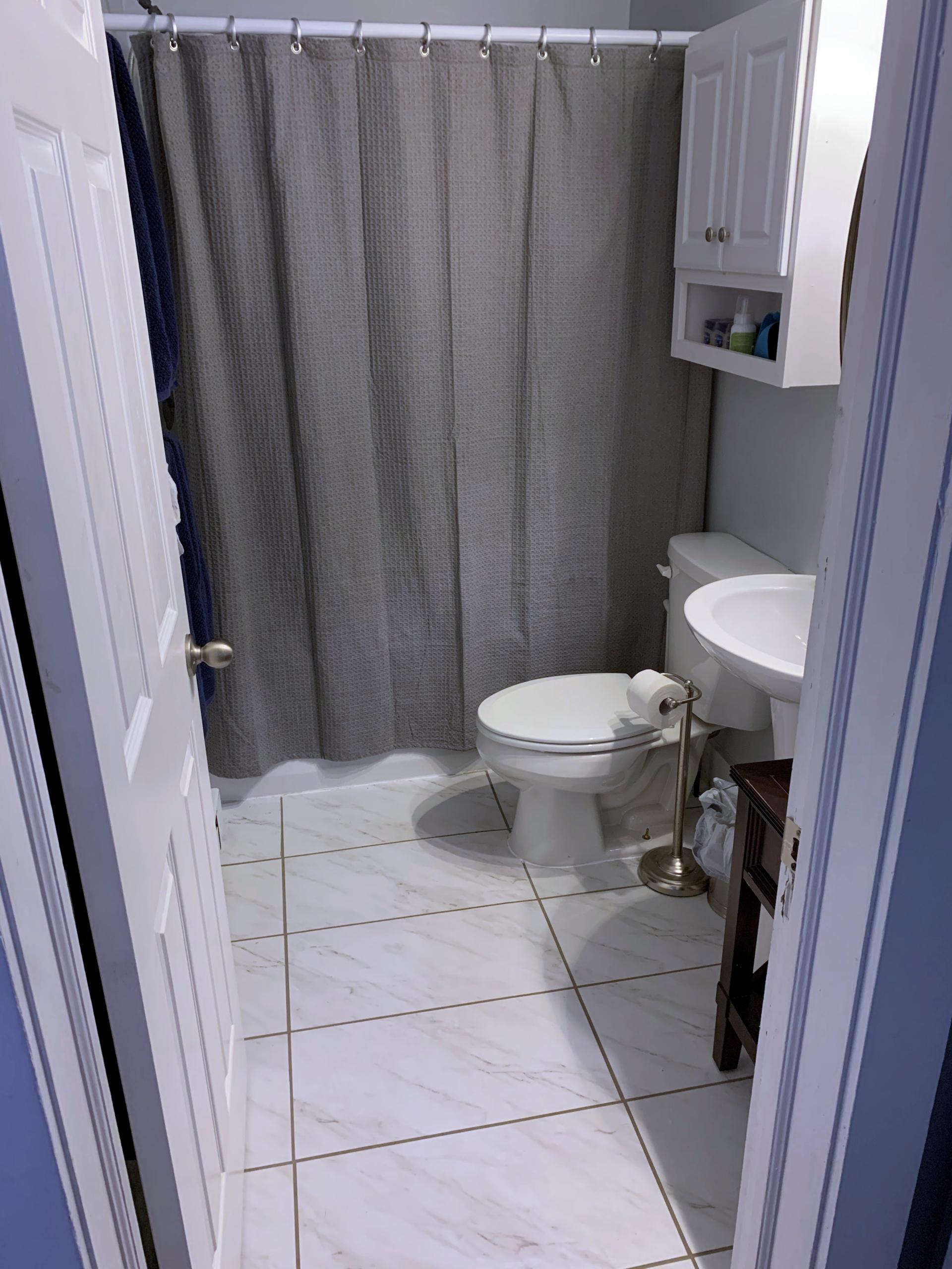 Bathroom with toilet, sink, and shower curtain